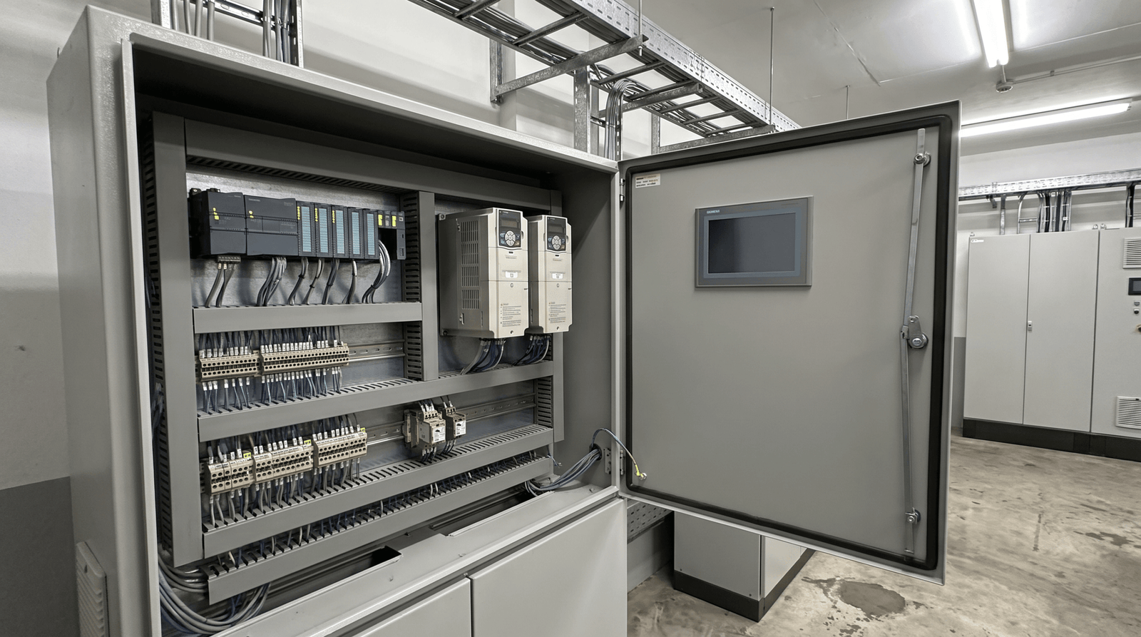 Tablero de control industrial con PLC y componentes de automatización para plantas de producción